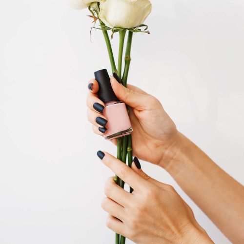 woman-holds-nail-varnish-and-flowers-beauty-salon-U2366SW.jpg